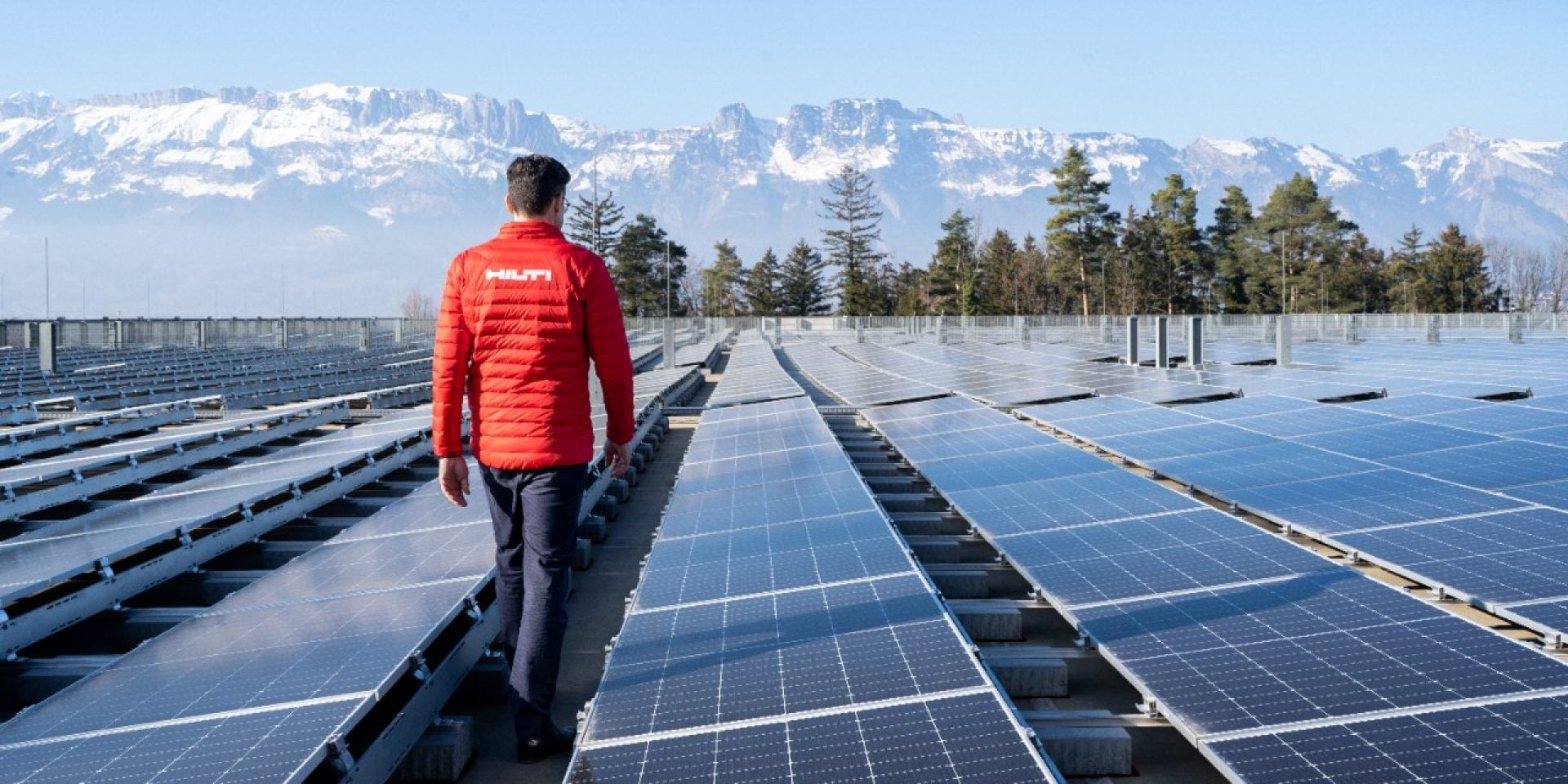 Um gestor de projectos Hilti caminha sobre um telhado com painéis solares