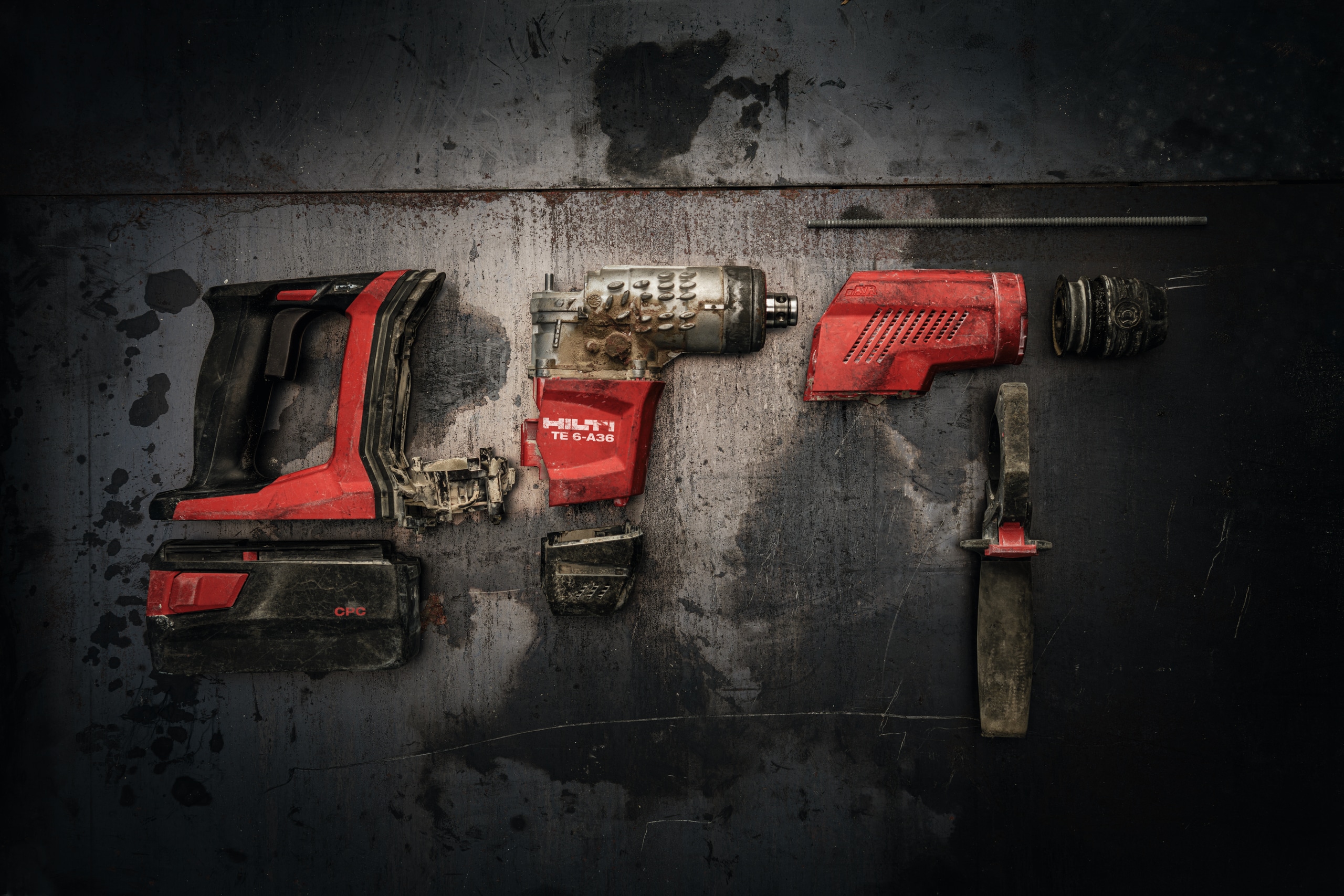 Um martelo rotativo Hilti desmontado em 3 peças