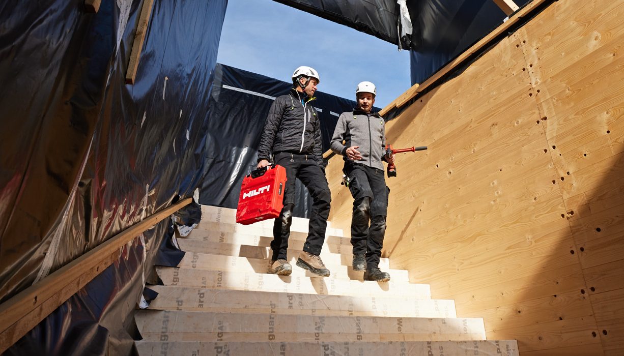 Dois trabalhadores estão realizando a avaliação de uma construção em madeira