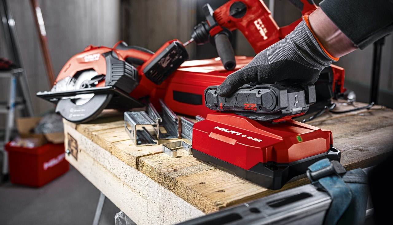 Uma mão a inserir uma bateria Hilti no carregador